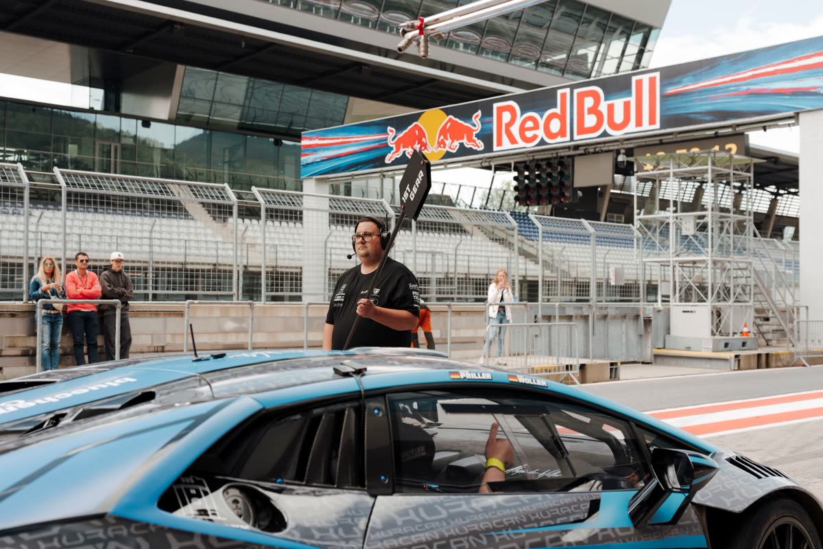 Instruktor mit Funk neben einem Lamborghini Huracán