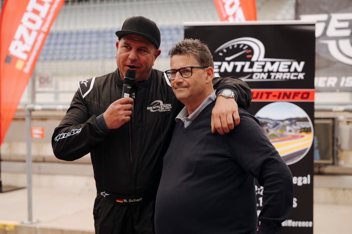 Mathias Scharf mit Mikrofon und Gast