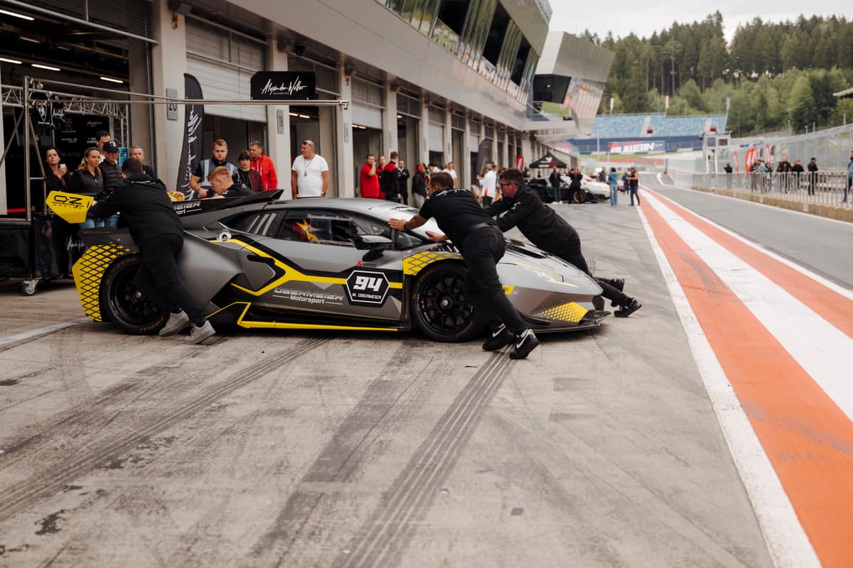 Crew schiebt einen Lamborghini Huracán in die Box