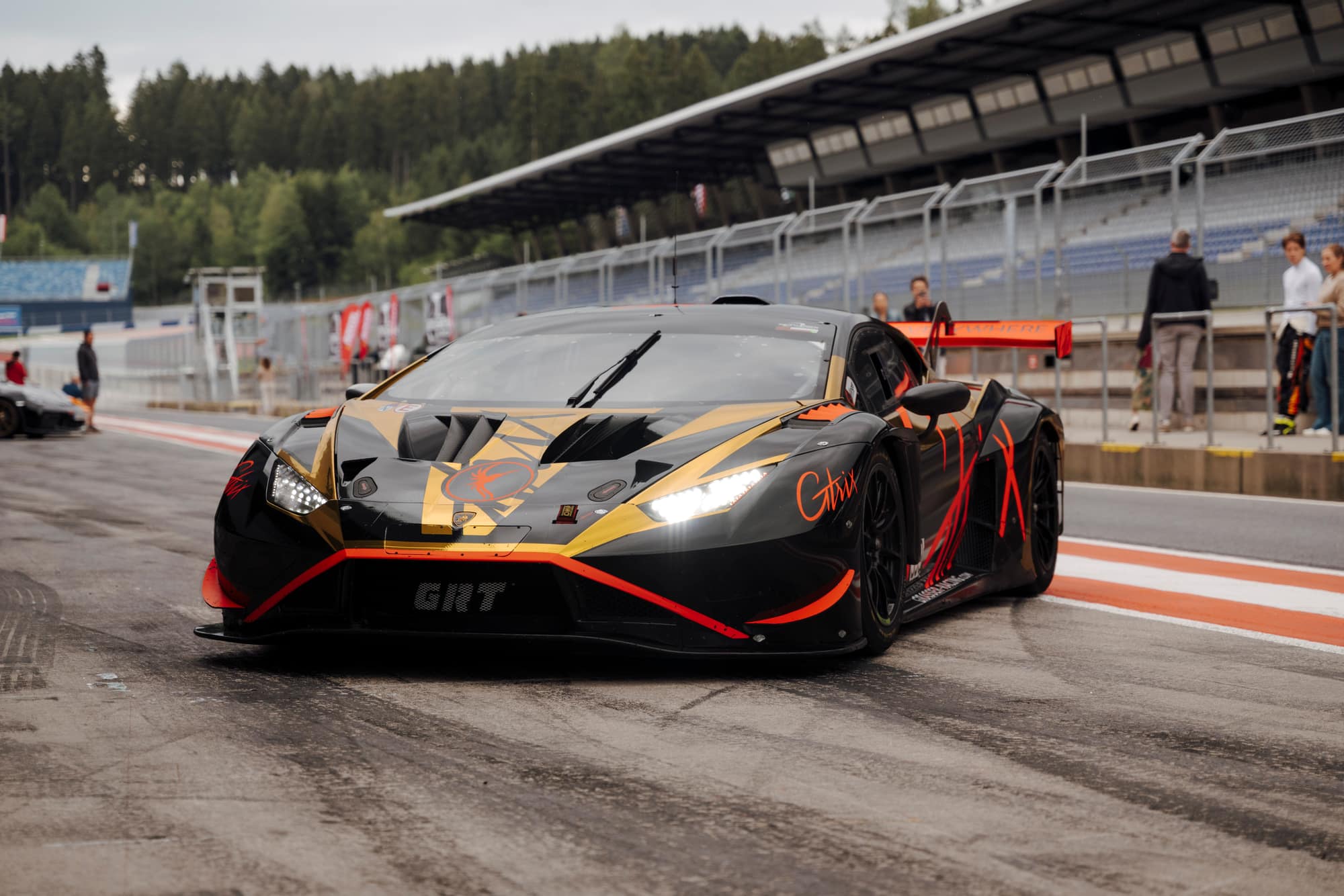 Schwarz-goldener Lamborghini Huracán rollt mit Licht durch die Boxengasse des Red Bull Rings