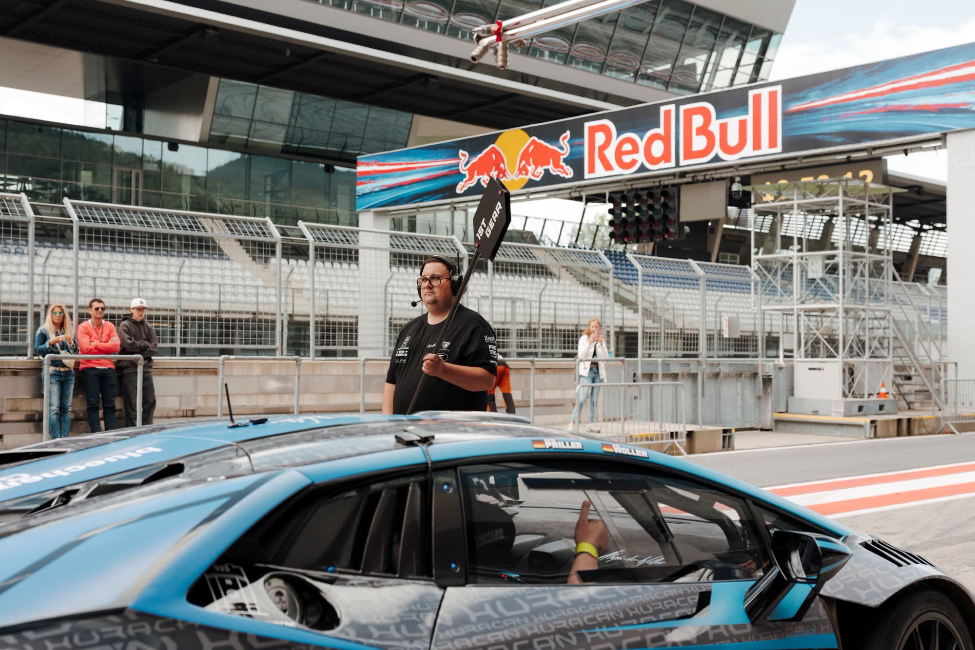 Instruktor mit Funk vor einem Lamborghini Huracán in der Boxengasse des Red Bull Rings